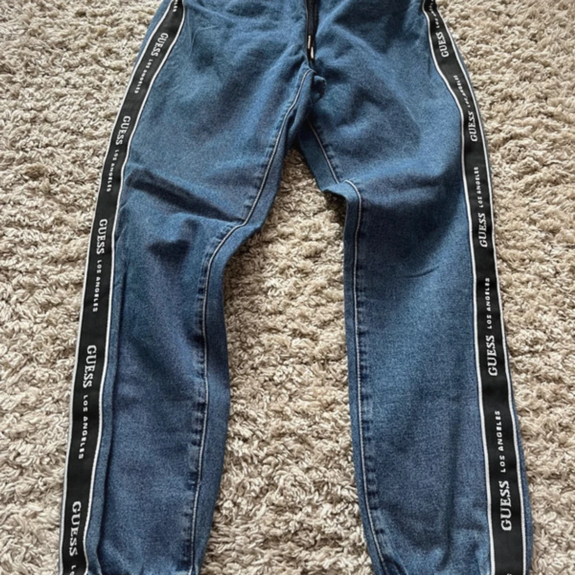 Blå jeansbyxor med logoband från Guess