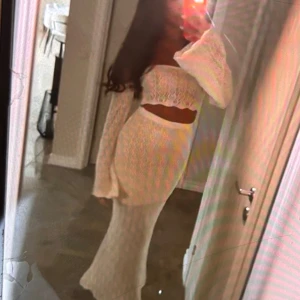 Vit långklänning med spets och vida ärmar - Säljer en vit långklänning med vackert spetsmönster och vida, långa ärmar. Klänningen har offshoulder-modell och en liten volangkant upptill samt vid ärmslut. Perfekt för dig som vill sticka ut med en romantisk look.