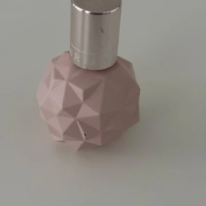 Parfymflaska i ljusrosa geometrisk design - Säljer en parfym från Ariana Grande i en unik ljusrosa flaska med geometriskt mönster och silverfärgat lock. Flaskan har en rund form och sticker ut med sin moderna, stilrena look. Perfekt för dig som gillar snygga detaljer på sminkbordet.