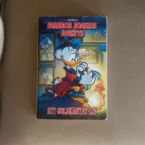 Farbror Joakims äventyr: Ett guldkantat liv - Säljer boken 'Farbror Joakims äventyr: Ett guldkantat liv' från Disney. Omslaget har en färgglad illustration av Joakim von Anka i röd rock och hög hatt, omgiven av tavlor och guld. Perfekt för dig som gillar serier och klassiska Disney-karaktärer.