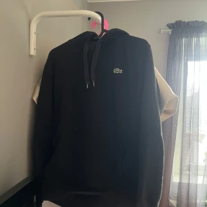Svart hoodie från Lacoste Sport och Svart hoodie från Wrangler - Säljer en svart hoodie från Lacoste Sport med klassisk krokodillogga på bröstet i storlek S. Tröjan har huva med dragsko och långa ärmar. Perfekt för en sportig och avslappnad stil. Den andra hoodien är från Wrangler i storlek M. Köp båda för 500kr och en för 300kr.🌷