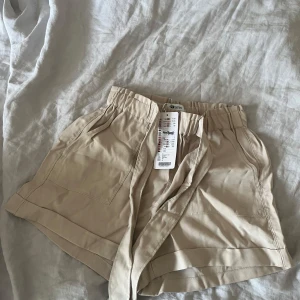 Beiga shorts med knytband. - Snygga beiga shorts från New Yorker. Prislapp kvar. 