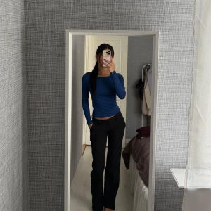 Mörkblå croppad långärmad topp - Säljer en mörkblå, tight och croppad långärmad topp med rund halsringning. Toppen är i ett stretchigt och mjukt material som sitter snyggt på kroppen. Perfekt att styla med både jeans och kostymbyxor.