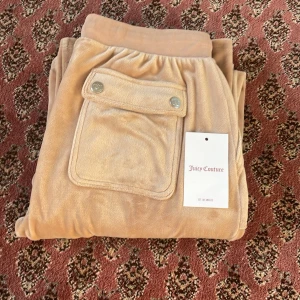Beige mjukisbyxor från Juicy Couture - Säljer dessa jättefina Juicy Couture mjukis byxor i nyskick. De är i storlek 14-15 år men passar mig som har storlek XS-S.🥰