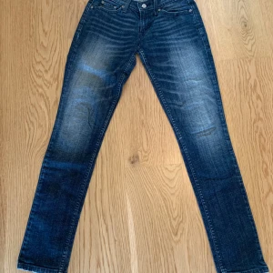 Mörkblå jeans från Levi's - Snygga mörkblå jeans från Levi's med klassisk femficksdesign och raka ben. Jeansen har en lätt tvättad look och silverfärgade knappar. Perfekta för en avslappnad stil.