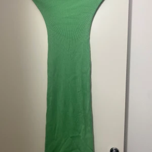 Grön ribbad långklänning H&M XS - Säljer en snygg grön ribbad långklänning från H&M i storlek XS. Klänningen är figurnära och har en enkel, stilren design med stretchigt material som sitter skönt. Perfekt för dig som gillar minimalistisk stil och vill sticka ut med färg.