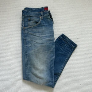 Blå Replay jeans med tapered fit - Säljer ett par blå jeans från Replay med snygg tvätt. Jeansen är lite stora i storleken skulle jag säga men skulle säga att de passar dig som är runt 190