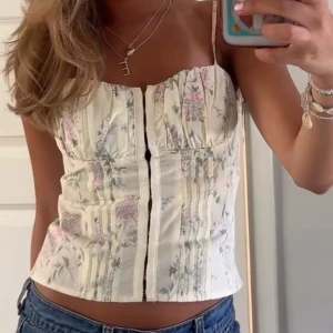 Blommig korsettopp  - Säljer denna superfina toppen från Gina tricot, jättesöt och perfekt nu till sommaren! Använd en gång så i jättebra skick, den är i storlek 34 vilket motsvarar ungefär XS! Första bilden är lånad!! 💞💞