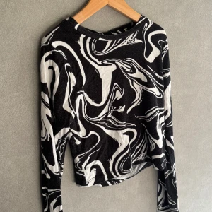 Långärmad svartvit topp från Gina Tricot - En tunn långärmad topp med svartvitt mönster från gina. Den är i storlek 134-140 och tyget är stretchigt.