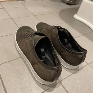Bruna mockasneakers med lackad tå - Snygga bruna lanvins i mocka med vit sula och lackad tå. Skorna har snörning och en klassisk låg profil som passar till det mesta. Defekter på skosnörena och lite framme vid tån. Köptes här på plick o dem har inte kommit till användning efter det😊 ingen skolåda skickades med. Pris går att diskutera 