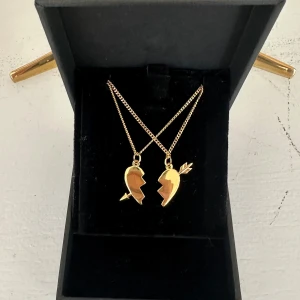 Arrow heart Halsband  - Två matchande silverhalsband med delade hjärthängen – perfekta att dela med en vän eller partner. Halsbanden är 100 % rost- och nickelfria. Kedjorna är 40 cm långa men kan förlängas med ytterligare 5 cm. Hör gärna av dig om du har några frågor ☺️