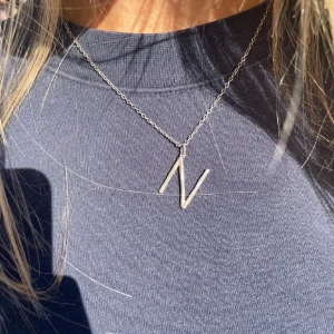 Silverhalsband med N-bokstav Maria Nilsdotter - N halsband i äkta silver från Maria Nilsdotter.  40 cm. Äkta såklart, får påse och smyckeslådan. Säg till om du har frågor!🩷🩷Säljer billigt då det är lite köpgrupp på grund av bokstaven.