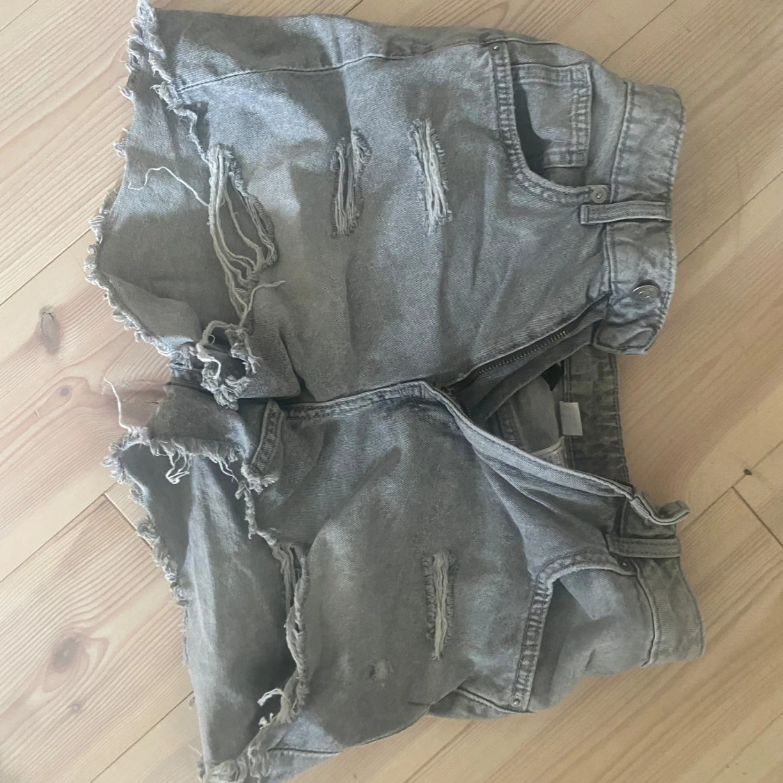 Grå slitna jeansshorts med fransar