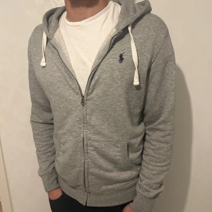 Ralph Lauren zip hoddie - | Snygg grå zip hoodie från Polo Ralph Lauren | tröjan är i mycket bra skick | storlek M | Nypris 1800 kr och mitt pris 799 kr | pris kan diskuteras!!!