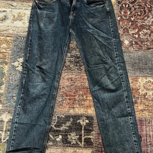 Blå jeans straight fit från Lindex - Säljer ett par klassiska blå jeans från Lindex i modellen Vilgot. Jeansen har rak passform, fem fickor och normal midja. Perfekta för dig som gillar en enkel och tidlös look. Materialet är tåligt denim i bomull. Storlek EUR 170