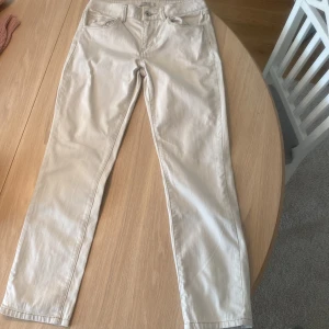 Beige raka byxor från Esprit - Snygga beige byxor från Esprit med raka ben och klassisk femficksdesign. Byxorna har broderade detaljer på bakfickorna och är tillverkade i mjuk material. Lågmidjade skinny byxor. Strl 29/30
