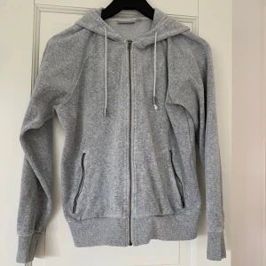 Grå hoodie med dragkedja från InWear - Mjuk och stilren ljusgrå hoodie från InWear. Tröjan har hel dragkedja framtill, två fickor med dragkedja, huva med snörning och långa ärmar. Perfekt för en chill och avslappnad look, den är mjuk och skön.