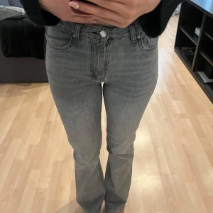 Gråa bootcut jeans med hög midja - Snygga grå jeans med bootcut-modell och medel hög midja. Jeansen har raka ben som blir lite utsvängda. 