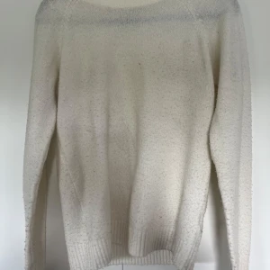 Vit stickad tröja från 157 - Mysig vit stickad tröja från 157 med rund halsringning och ribbade muddar vid ärmslut och nederkant. Långärmad och enkel att matcha med jeans eller kjol. Storlek 160 men skulle säga att den sitter som en S/M!