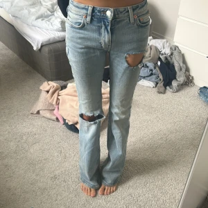 Ljusblå lågmidjade bootcut jeans - Säljer ett par ljusblå bootcut jeans som är lågmidjade.Jeansen har hål som jag har gjort själv!