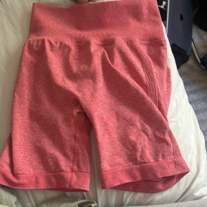 Rosa  seamless träningsshorts - Snygga rosa seamless träningsshorts med hög midja och ribbade detaljer längs sidorna. Materialet är stretchigt och andas, perfekt för gymmet eller andra sportaktiviteter. OBS en pytteliten defekt men inget som stör eller ändrar funktionen 💗💗 priset går att diskutera!