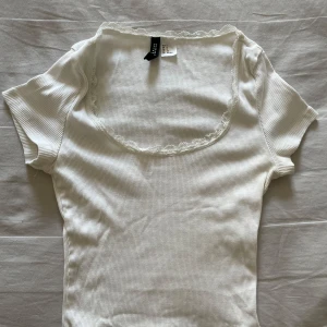 Vit ribbad topp med spets  - Supersöt vit ribbad topp med korta ärmar och rundad halsringning dekorerad med spetskant. Den är i mycket bra skick och i storlek S