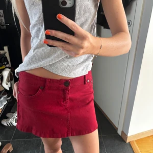 Röd jeanskjol - Snygg röd jeanskjol med klassiska fickor fram och bak samt coolt märke på baksidan. Kjolen är kort och har en normal passform.