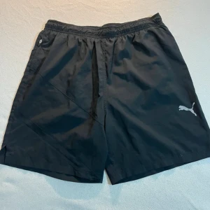 Svarta träningsshorts från Puma - Svarta shorts från Puma med storlek M dom är väldigt fina fast något. Ni bör veta att den funkar för mer dom med storlek S