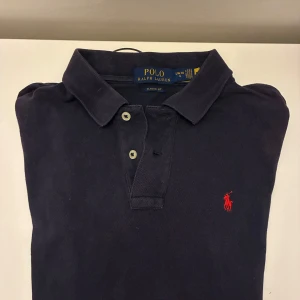  pikétröja från Ralph Lauren - Klassisk mörkblå pikétröja från Polo Ralph Lauren. Storlek L (barn 14-16år) passar XS i vuxenstorlek. Skriv vid frågor och funderingar.