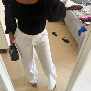 Vita wide kostymbyxor med hög midja - Säljer ett par vita kostymbyxor med hög midja och breda ben. Byxorna har klassiska fickor fram, knapp och dragkedja i midjan samt ett stilrent, elegant snitt. Perfekta för dig som gillar en clean och trendig look.