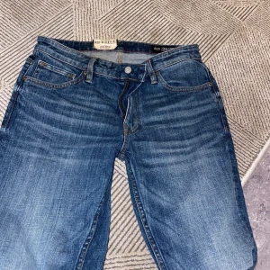 Levi's 511 Skinny Jeans Blå 29/32 - Säljer ett par Levi's 511 skinny jeans i klassisk blå tvätt med snygga slitningar och femficksdesign. Jeansen har smal passform, normal midja och är gjorda i mjukt jeansmaterial med stretch för extra komfort. Perfekta för dig som gillar en modern och clean look.