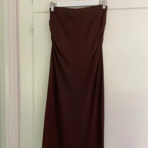 Brun långkjol från Nelly - Säljer en brun långkjol från Nelly i storlek XS. Kjolen har snygga rynkdetalj på sidan och är figursydd. Jag är 167cm och den går ner till fötterna på mej. Vet ej fraktkostnaden.