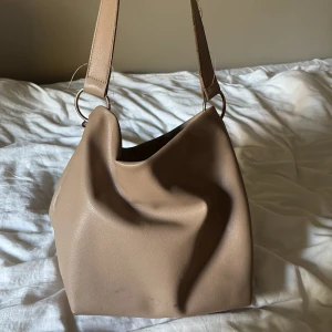 BEIGE AXELVÄSKA Carin Wester - Snygg och stilren beige axelväska från Carin Wester. Perfekt för skolan! Man får plats med mycket.