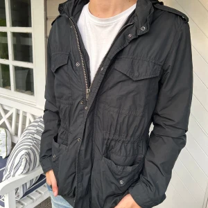 Field Jacka - Säljer nu denna snygga field jacka i svart färg från GAP! Inga deffekter använd fåtalet gånger! Den är dock ruskigt snygg och kommer passa perfekt nu till kommande väder!😇🌼Modellen på bilden är 1,83cm och väger 73kg hör av dig vid vidare fundering🤝
