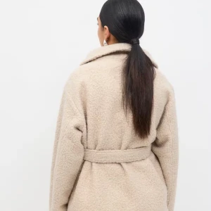 Beige teddyjacka med bälte från Gina Tricot - Supermjuk och oversized teddyjacka i beige från Gina Tricot. Jackan har bred krage, knytbälte i midjan och långa ärmar. Perfekt för kalla dagar och ger en chill vibe till din outfit.