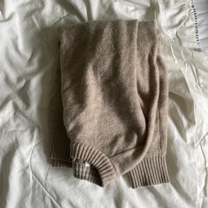 Beige stickad tröja från Selected Homme - Beige stickad tröja från Selected Homme med rund halsringning och breda ribbade muddar vid ärmslut och nederkant. Perfekt för lager-på-lager och chill höst- eller vinterstil. Enkel att matcha med jeans eller chinos.