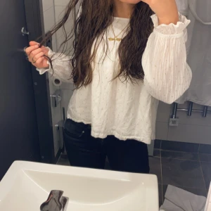 Vit blus med guldiga detaljer Gina Tricot - Supersöt vit blus från Gina Tricot med diskreta guldiga broderade detaljer. Blusen har långa puffiga ärmar med resår och volang vid ärmslut och axlar. Luftig och flowy passform, perfekt till jeans eller kjol. Rund halsringning och knapp i nacken. Endast använd fåtal gånger. Säljer pga rensar ut min garderob och den inte kommit till användning.