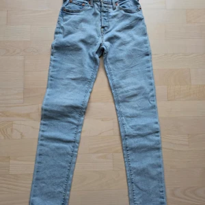 Ljusblå Levi's skinny jeans 152 cm - Säljer ett par ljusblå skinny jeans från Levi's i klassisk femficksmodell. Jeansen har hög midja, smal passform och är tillverkade i mjukt denimtyg. Perfekta för dig som gillar en clean och enkel look. Litet hål i grenen som går att laga.