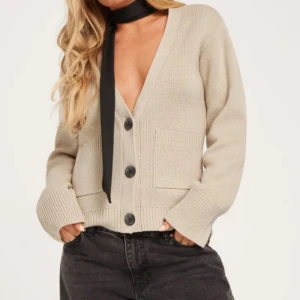 Stickad Nelly kofta med knappar - Populär slutsåld beige stickad cardigan från Nelly med svarta knappar. Såå snygg!