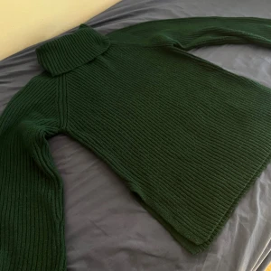 Mörkgrön polotröja från Gina Tricot - Mysig mörkgrön polotröja från Gina Tricot i ribbstickat material. Tröjan har lång ärm, hög polokrage och en loose fit som ger en chill vibe. Perfekt för lager på lager under höst och vinter. Snygg att styla med jeans eller kjol.