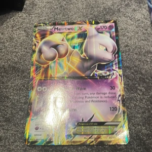 Mewtwo EX - Stor, glittrande Pokémonkort med Mewtwo EX! Perfekt för samlare och fans som vill ha något unikt i sin samling. Kortet har cool design och passar både för spel och display. Ett måste för dig som älskar Pokémon och vill sticka ut bland vännerna!
