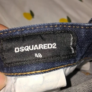 Dsquared2 jeans - Snygga mörkblå jeans från Dsquared2 med coolt stänk-mönster och tryck på bakfickan. Jeansen har raka ben, klassiska bakfickor och detaljerad sömnad. Materialet är robust denim som ger en schysst streetkänsla. CIAO BELLA med påsen ochså helt nya 