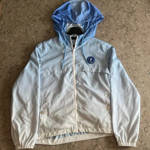 Trapstar jacka - Säljer en trapstar jacka, står trapstar på ryggen med blå text.det är en windbreaker som fungerar bra emot vind. Ingett slitet på den eller nått. Pris kan sänkas vid snabb affär.