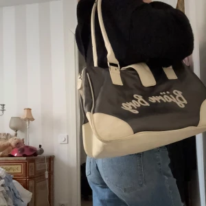 Svart och beige axelväska från Björn Borg - Säljer en svart och beige axelväska från Björn Borg med tydlig logga på framsidan. Väskan har långa handtag och detaljer i beige, samt dragkedja upptill. Perfekt storlek för vardagsprylar och enkel att bära över axeln.