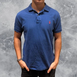 Ralph Lauren Piké blå - •Ralph Lauren Piké blå. Skick: 8/10, Inga skador! Storlek: S Custom Fit, dvs vanlig svart passform. Modell: 173 cm, 63 kg. Authentic: ✅. Hör av dig vid frågor eller funderingar, mvh Hessler’s;)