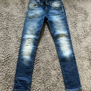 Blå jeans från Jack & Jones - Snygga blå jeans från Jack & Jones med en slim fit passform. De har en klassisk femficksdesign och slitna detaljer för en trendig look. Perfekta för en avslappnad stil storlek 31 midja längd 32