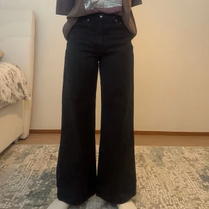 Svarta wide jeans från gina (158cm)  - Säljer ett par svarta jeans från ginatricot för mina short girlies 💞Är 158 cm och dessa är perfekta i längden! De är i storlek 32 MEN jag har storlek 34 och de passar perfekt.  Byxorna har en hög midja och vida ben för en avslappnad look. 