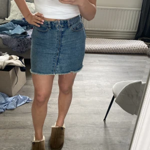 Jeanskjol med rå kant - Säljer en snygg jeanskjol med rå kant och hög midja. 