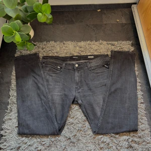 Replay anbass jeans i färgen grå,svart! - Snygga jeans från Replay med klassisk femficksdesign och knappgylf. De har en stilren look med diskreta detaljer och en bekväm passform. Skicket är 8,5/10, hör av er vid frågor!