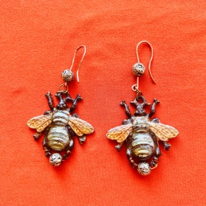 Unika bi-örhängen i metall - Säljer coola örhängen formade som bin med guldfärgade vingar och detaljerad kropp i mörk metall. Perfekt accessoar för dig som vill sticka ut och addera något annorlunda till din stil.